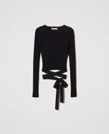 Remera negra de punto con textura acanalada, cuello redondo y mangas largas. Presenta un lazo en la cintura que se ata en la espalda.