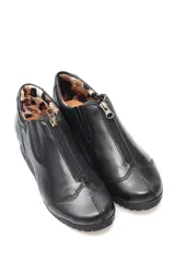 Bota de cuero color negro, estilo botín, con detalle de cierre en la capellada.