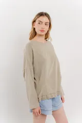 Remera color arena de corte holgado y mangas largas.