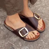 Sandalia de cuero color chocolate con hebilla dorada ajustable y plantilla anatómica de corcho.