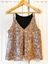 Musculosa de fiesta con escote en V y breteles finos, completamente cubierta de lentejuelas en tono dorado rosado.