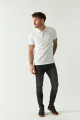 Remera polo blanca de manga corta, con cuello clásico, cierre de tres botones y logo estampado en el pecho.