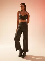 Pantalón negro de cuero sintético, corte recto y tiro alto.