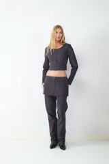 Minifalda de tiro bajo con diseño de raya diplomática, corte recto y cierre frontal con cremallera metálica. Presenta bolsillos decorativos en la parte delantera.