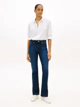 Camisa blanca de algodón orgánico con cuello camisero, cierre frontal de botones y manga larga ajustable con presilla. Cuenta con el logo de Tommy Hilfiger bordado sutilmente en el pecho.