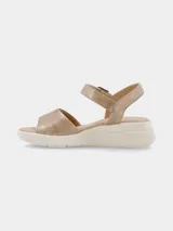 Sandalia de plataforma color beige con textura reptil, tira frontal ancha y tira ajustable en el talón con hebilla metálica.