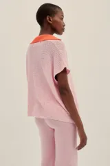 Pantalón tejido color rosa con terminaciones en crochet color naranja, de largo hasta los tobillos, con un fit holgado y cintura elastizada.