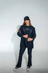 Blazer de lycra color negro, con diseño de solapas amplias y bordados de alas en el frente. Presenta un corte holgado y moderno con mangas largas.