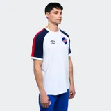 Remera de algodón azul con mangas raglán rojas y detalles en blanco en cuello y puños. Incluye logo de Umbro bordado en el pecho y escudo del Club Nacional de Football.