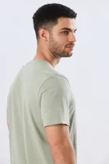 Remera azul marino de manga corta con cuello redondo y estampa frontal de un paisaje de playa con palmeras y el texto 'Legacy Beach Club'.
