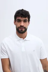 Remera polo verde militar de algodón pima, con cuello y puños acanalados, cierre frontal de tres botones y pequeño bordado de ave en el pecho.