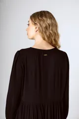 Vestido midi negro con corte en la cintura y falda amplia con volados.