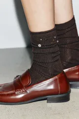Calcetines de lana en tejido rib color marrón chocolate, con aplicación de joyas y abalorios decorativos en la parte superior.