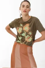 Remera lila de algodón con estampado de flores en tonos naranja y rosa.