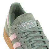 Championes adidas Handball Spezial de gamuza en color verde oliva con las icónicas tres tiras y detalle en el talón en color rosa pastel. Presenta suela de goma color caramelo y el nombre del modelo grabado en el lateral.
