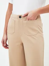 Pantalón beige de corte acampanado con bolsillos delanteros con solapa y botón.