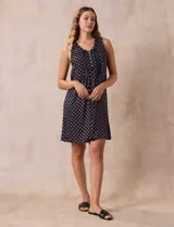 Camisón corto negro con estampado de lunares blancos, escote en V con botones y detalle plisado en el pecho.