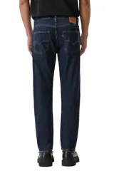 Pantalón de jean corte slim taper, con ajuste entallado en el muslo y pierna que se estrecha hacia el tobillo. Presenta un lavado azul oscuro clásico con costuras en contraste y cierre frontal con botón y cremallera.