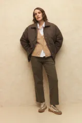 Campera capitoneada negra con botones veteados, bolsillos laterales de solapa y forro de satén con estampado animal print.