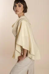 Ruana corta de lana fina sin teñir, con terminación de crochet hecho a mano. Diseño versátil y cómodo, ideal para usar durante todo el año.