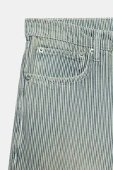 Jeans de tiro bajo y corte recto, confeccionados en denim con estampado de rayas verticales y efecto lavado. Presenta cinco bolsillos, trabillas en la cintura, cierre frontal con cremallera y botón, y un detalle de rotura en la parte delantera.