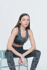 Top deportivo gris con estampado abstracto en negro, espalda cruzada y compresión alta.