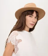 Sombrero de fieltro negro, estilo cowboy, con ala ancha y una fina cinta de cuero sintético con hebilla metálica dorada alrededor de la copa.