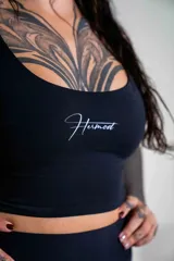 Top deportivo negro de corte ajustado con escote redondo y logo de la marca estampado en el centro del pecho. Confeccionado en tejido técnico de alta elasticidad.