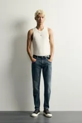 Jeans skinny fit de color azul, con efecto lavado y detalles de roturas en las piernas. Diseño de cinco bolsillos, tiro medio y cierre frontal con cremallera y botón.