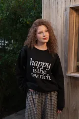 Buzo de cuello redondo gris melange con estampa frontal en negro con la frase "happy is the new rich".
