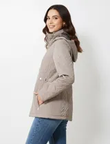 Campera de abrigo color marrón, con diseño capitoneado de costuras entrelazadas en relieve. Presenta cuello alto, capucha desmontable, cierre frontal completo y bolsillos laterales con cierre. Incluye trabas ajustables en la cintura con botones metálicos para entallar la silueta.