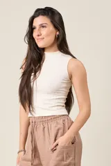 Musculosa de punto acanalado color crudo, con cuello alto y corte ajustado.