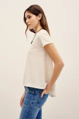 Remera básica de corte holgado, color negro, con mangas cortas y cuello redondo. Presenta un diseño con largo irregular y ruedo redondeado, confeccionada en algodón peruano con textura jaspeada.