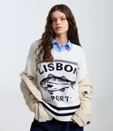 Suéter de punto color blanco con escote en V, manga larga y diseño holgado. Presenta un estampado frontal en color negro con el texto 'LISBON PORT' y un dibujo de un pez, además de detalles de rayas horizontales en el ruedo.