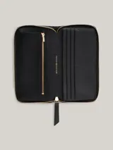 Billetera Tommy Hilfiger negra de piel sintética acolchada con cierre de cremallera y logo metálico dorado.