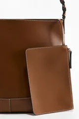 Cartera marrón con correa trenzada y hebilla cuadrada de metal.