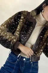 Campera corta de piel sintética con estampado animal print tipo ciervo, cuello clásico, cierre frontal y puños elásticos en cuero sintético.