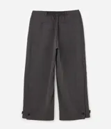 Pantalón de sastrería gris de corte wide leg, con cintura alta, bolsillos laterales y detalles de ajustes con botones en los ruedos.