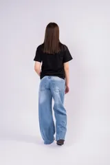 Pantalón de jean tiro bajo con corte wide leg y lavado celeste vintage. Presenta un diseño de pernera ancha y recta, con cierre de botón y cremallera, y bolsillos laterales y traseros.