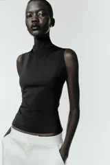 Camiseta sin mangas de corte ajustado con cuello subido, confeccionada en tejido liso de color marrón.