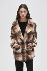 Tapado de lana con diseño a cuadros en tonos marrones y beige, de corte holgado, con cuello de solapa y cierre frontal con botones.