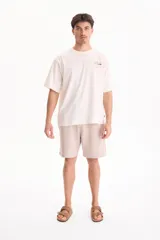 Remera oversize de manga corta color blanco, confeccionada en 100% algodón, con estampado gráfico en la espalda que incluye el texto "Los Angeles, PARADISE CITY" y un dibujo de un auto clásico.