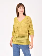 Buzo de tejido de punto calado en color amarillo mostaza, con escote en V y mangas tres cuartos.