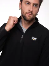 Buzo polar de microfibra color negro, con cuello alto y cierre frontal de cuarto de longitud. Presenta el logo de la marca Caterpillar aplicado en el pecho.