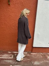 Saco abierto de punto, color marrón, con mangas largas y diseño holgado sin botones.