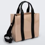Cartera tipo tote bag Melissa modelo Dulce Bag, de color beige con acabado brillante, doble asa de mano negra y correa ajustable para hombro. Las asas principales incorporan bandas negras con el logotipo de la marca grabado.