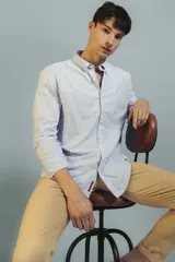 Pantalón de gabardina color beige, de corte recto y ajuste clásico, con cierre frontal y bolsillos laterales.