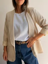Blazer sastrero de corte clásico con solapas frontales y bolsillos con solapa. Presenta mangas largas con puños vueltos y un diseño forrado que ofrece una caída estructurada y elegante.