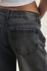 Jean wide leg de tiro bajo, color negro con efecto lavado stone black, de corte holgado y diseño clásico de cinco bolsillos.