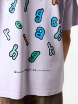 Camiseta lila de algodón orgánico, con corte oversize y estampado gráfico colorido en la espalda.